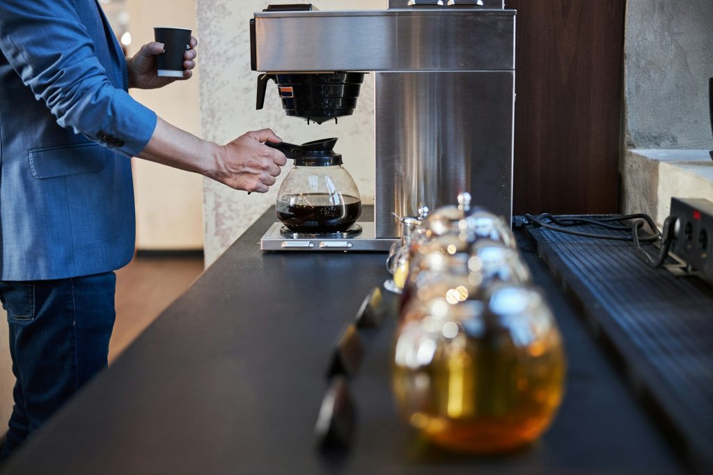 Elegant gentleman serving himself coffee at hotel eatery